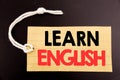 Word, writing Learn English. Business concept for online sale Language School written on price tag paper on the black vintage back Royalty Free Stock Photo