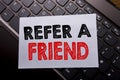 Word, writing Refer A Friend. Business concept for Referral Marketing written on sticky note paper on the dark keyboard background