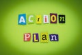 A word writing text - action plan. Cut colorful letters on a yellow and green background. Headline on banner. Inscription. Plannin