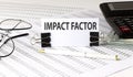 Word writing text IMPACT FACTOR on white sticker on chart background. Business concept Royalty Free Stock Photo