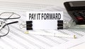 Word writing text PAY IT FORWARD on white sticker on chart background. Business concept Royalty Free Stock Photo