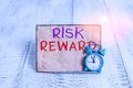 Word writing text Risk Reward. Business concept for assess the profit potential of a trade relative to its loss Mini blue alarm Royalty Free Stock Photo