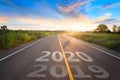 The word 2020 written on highway road in the middle of empty asphalt road at golden sunset and beautiful blue sky Royalty Free Stock Photo