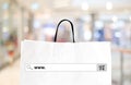 Word www. on search bar over shopping bag and blur store background Royalty Free Stock Photo