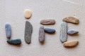 Word "Life" written using colored stones on white sand Royalty Free Stock Photo
