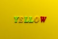 Word `yellow` from plastic colored magnet letters on yellow pape