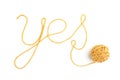 Word yes made of yellow thread and thread ball isolated on white background. Royalty Free Stock Photo
