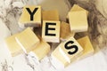 The word yes is written in black letters on wooden blocks. Message Yes on a light background. Royalty Free Stock Photo