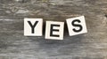 The word Yes. written in black letters on wooden blocks. Message spells Yes on white background. Royalty Free Stock Photo