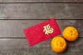 Wording of happiness on the red envelop with tangerines.