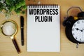 WordPress Plugin text written on notepad with alarm clock and magnifying glass flat lay on wooden background Royalty Free Stock Photo