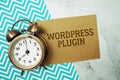 Wordpress Plugin text written on paper card with alarm clock on marble background Royalty Free Stock Photo