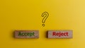 The words accept and reject on wooden blocks with question mark symbols. Dilemma or choice between to approve or to refuse an