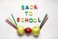 Words BACK TO SCHOOL made of color letters with apples and pencils on white background