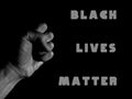 Words Black Lives Matter next to the clenched fist of a person on  a black background Royalty Free Stock Photo