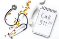 The words Call 911 written in a notebook near phone handset on white background top view Royalty Free Stock Photo