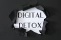 Words DIGITAL DETOX on white background, view through hole in black paper Royalty Free Stock Photo
