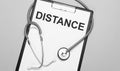 The words distance is written on white paper on a grey background near a stethoscope. Medical concept