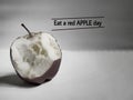 words of eat a red apple day with eaten apple background Royalty Free Stock Photo