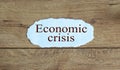 Words `Economic crisis` on the piece of paper. Wooden table Royalty Free Stock Photo