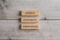 Words Ethics, Integrity and Principles written on three stacked wooden blocks