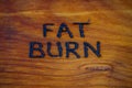 The words fat burn handritten on wooden surface with woodburner Royalty Free Stock Photo