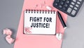 The words Fight for Justice written on a white notebook. Closeup of a personal agenda. Top view. Office concept