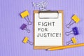 The words Fight for Justice written on a white notebook