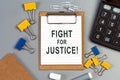 The words Fight for Justice written on a white notebook