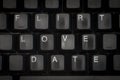 The words flirt, love, date on a black keyboard