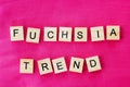 The words fuchsia trend is written in cubic letters on a bright pink color textile background, selective focus Royalty Free Stock Photo