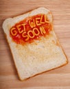 The words get well soon spelled out on a slice of tast with alphabet spaghetti