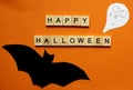 Words Happy Halloween. Wooden blocks with inscription on orange background are decorated with bats and paper ghosts. Bulletin Royalty Free Stock Photo