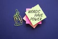 Words have power symbol. Yellow steaky note with paper clips with words Words have power. Beautiful deep blue background. Business Royalty Free Stock Photo