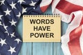 Words have power text on notebook, glasses, pen.