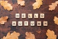 Words Hello autumn and dry oak leaves on wooden background. Education, back to school concept, top view, flat lay Royalty Free Stock Photo