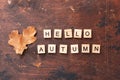 Words Hello autumn and dry oak leaves on wooden background. Education, back to school concept, top view, flat lay Royalty Free Stock Photo