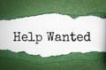 the words help wanted appearing behind torn white paper, green background Royalty Free Stock Photo