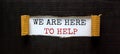 The words `we are here to help` appearing behind torn black paper. Beautiful background. Business concept