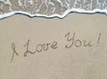 Words I love you outline on sand with wave brilliance