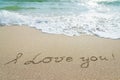 Words I love you outline on wet sand with wave Royalty Free Stock Photo