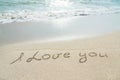 Words I love you outline on the wet sand