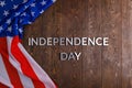 the words independence day laid on brown wooden planks surface with crumpled unated states of america flag