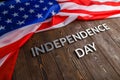 the words independence day laid on brown wooden planks surface with crumpled united states of america flag