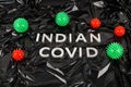 words indian covid laid with silver metal letters on crumpled black plastic bag background with small virus models Royalty Free Stock Photo