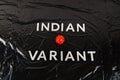 words indian variant laid with silver metal letters on crumpled black plastic bag background, close-up with small virus Royalty Free Stock Photo