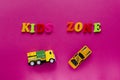 Words `kids zone` with toy cars on pink background. Royalty Free Stock Photo