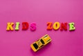 Words `kids zone` with toy cars on pink background Royalty Free Stock Photo