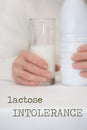 Words LACTOSE INTOLERANCE. Senior woman and a glass of milk in the background