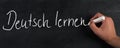 The words learn german are standing  on a blackboard Royalty Free Stock Photo